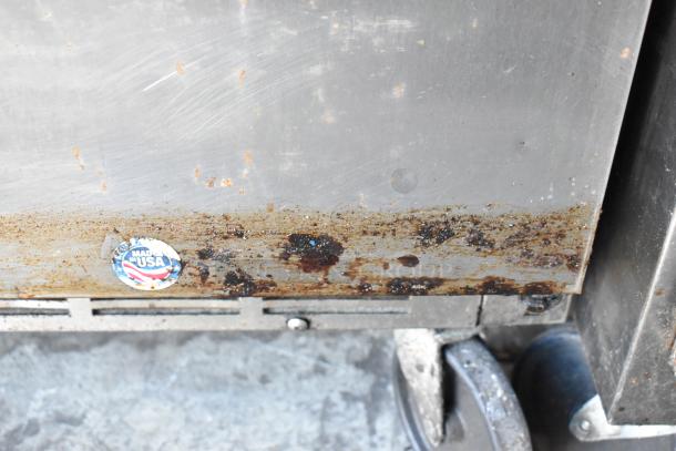 Beverage Air SPE48-18M stainless steel prep table with visible wear and grime, on commercial casters. Made in USA label.