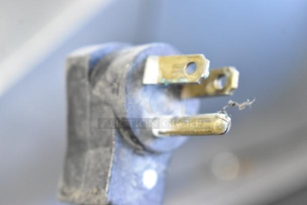Close-up of a worn power plug on the Beverage Air SPE48-18M prep table, showing brass prongs with slight corrosion.