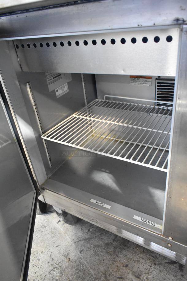 Beverage Air SPE48-18M stainless steel sandwich prep table, features wire shelving and label slots, on commercial casters.