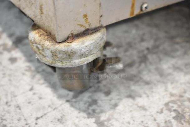 Close-up of a caster wheel on a 2019 Alto Shaam 750-S stainless steel heated holding cabinet, showing signs of wear.
