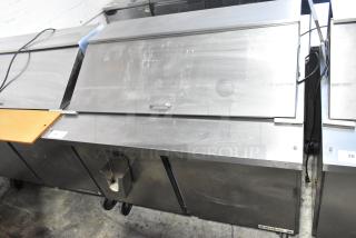 Beverage Air SPE48-18M stainless steel sandwich prep table with cover, commercial casters, scratches visible, 48-inch.