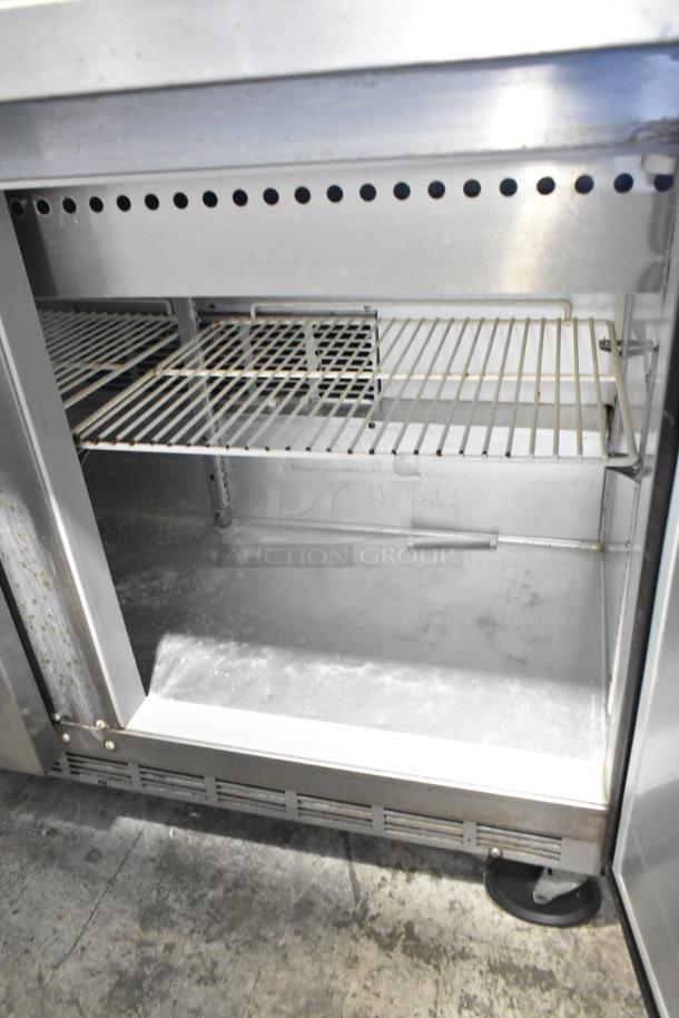 Beverage Air SPE48-18M stainless steel commercial prep table with open door, showcasing wire shelves and commercial casters.
