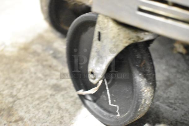 Beverage Air SPE48-18M stainless steel prep table on commercial caster, showing wheel detail.