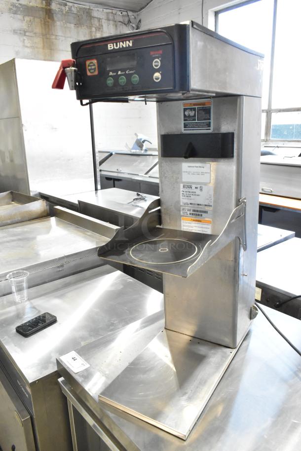 Bunn ITCB-DV stainless steel iced tea machine with hot water dispenser, 120V, shown on a countertop with visible labels.
