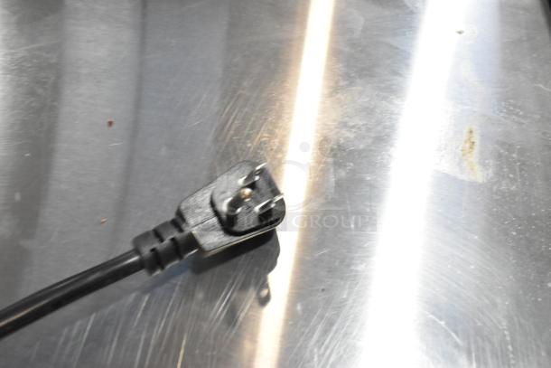 Close-up of a power plug for the 2019 Habco SE18 commercial cooler. Black cord on a reflective surface.