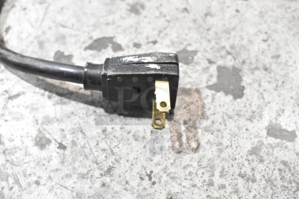 Power plug for True GDM-12 cooler, showing a three-prong configuration on a metal surface.