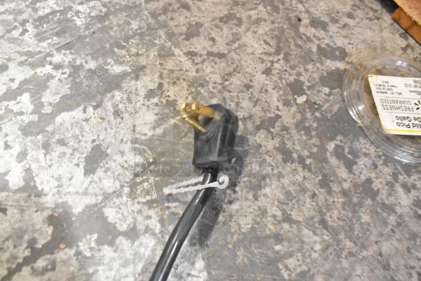 Blurred close-up of a power cord plug on a textured surface, not showing the Habco SE18 cooler.