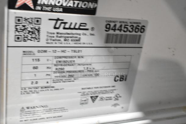 2018 True GDM-12-HC metal cooler, single door, poly coated racks, 115V, labeled with model and serial number details.