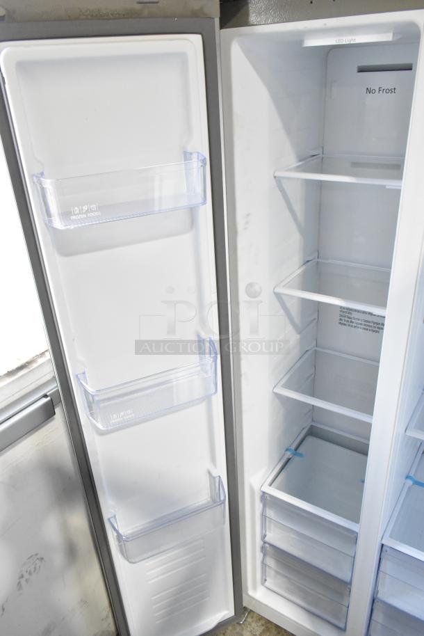 Hamilton Beach HBF1558/HZ8551 stainless steel reach-in cooler with freezer, featuring adjustable shelves and door bins, in clean condition.
