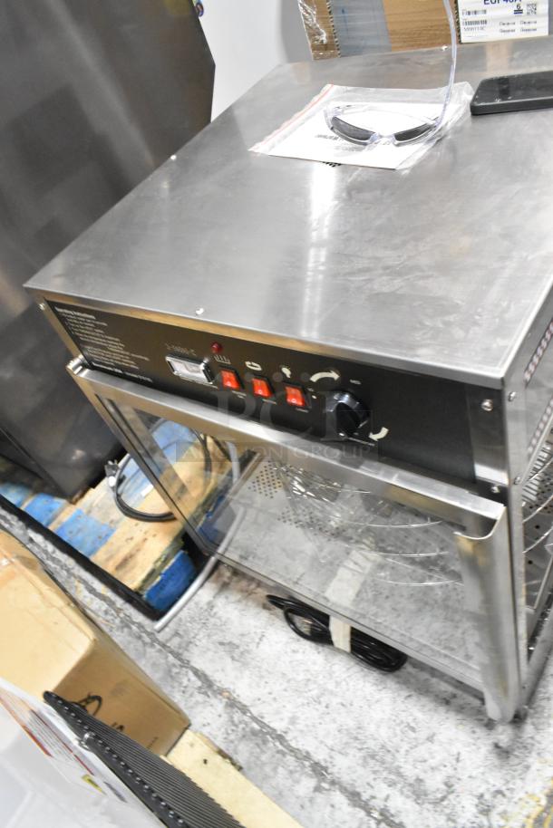 BRAND NEW Benchmark USA 51018 humidified rotating pizza/pretzel warmer with 18" rack, 120V, minor scratches and dents visible.