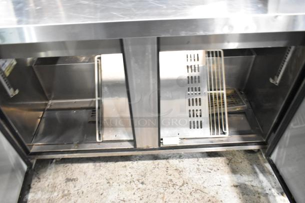 Turbo Air MST-48-18 stainless steel commercial prep table with open storage, showing interior racks and commercial casters.