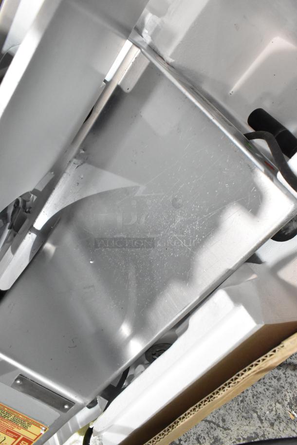Bizerba SE 12 US metal commercial countertop meat slicer showing stainless steel surface and components. 120V, 1 phase.