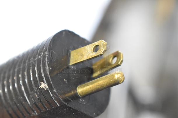 Close-up of a three-pronged plug for JBT 2ND-GEN-MFJ-HE citrus juicer, showing metal prongs and ridged plastic housing.