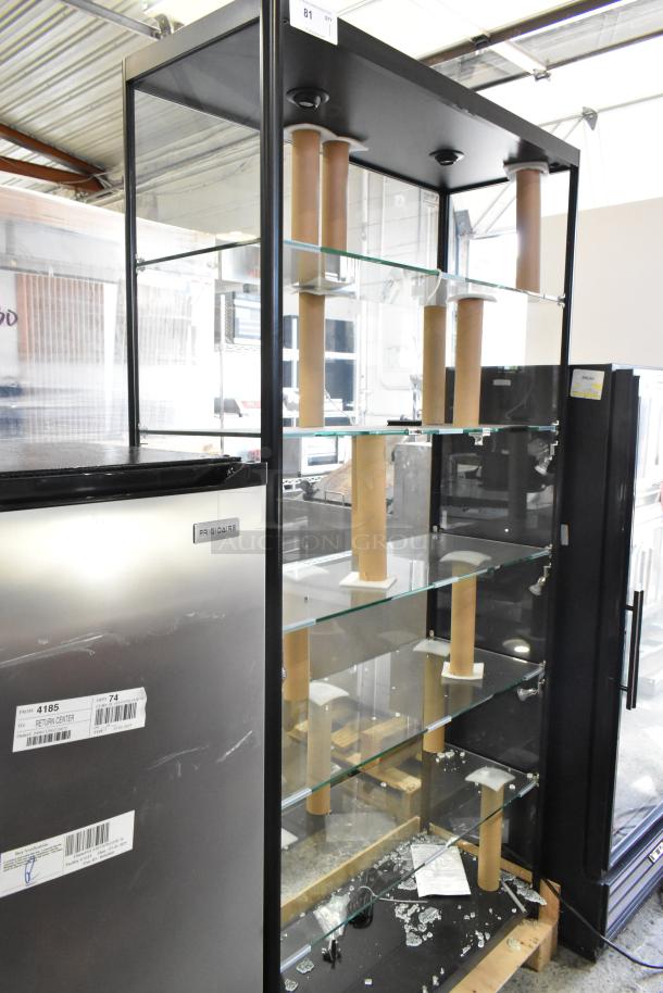 Metal and glass dry display case with multiple shelves. Visible broken glass on lower shelf. Black frame, used condition.