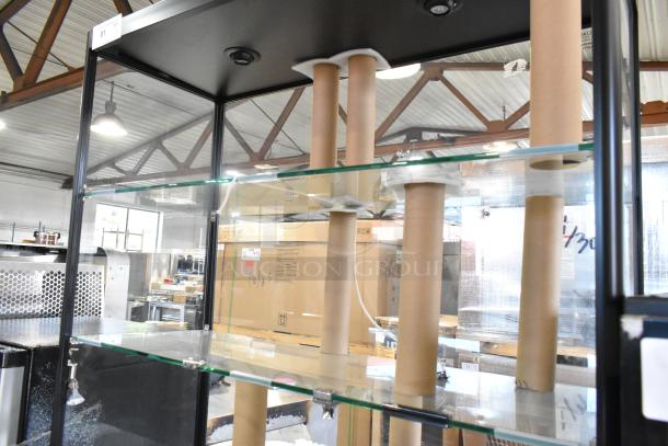Metal and glass dry display case with multiple shelves. Noticeable broken glass pieces. Durable metal frame. Ideal for retail display.