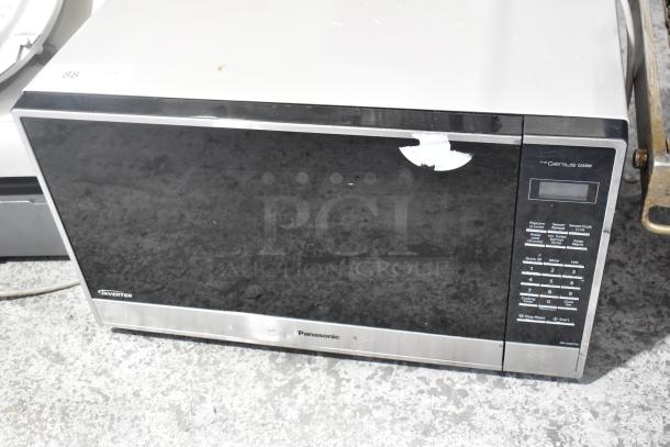 Panasonic NN-SN975S metal countertop microwave oven, black and stainless steel finish, visible control panel, worn condition.