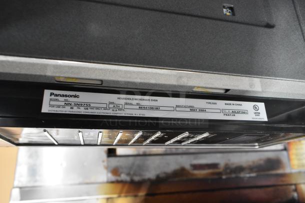 Panasonic NN-SN975S countertop microwave oven with plate, 120V, 1 phase. Features label indicating model and specs.