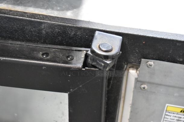 Beverage Air BB72G commercial 3-door cooler hinge detail, shows sturdy metal construction and slight wear.