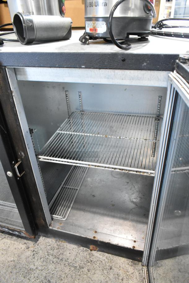 Beverage Air BB72G commercial 3-door bar cooler. Metal interior, shelving visible. 115 volts, 1 phase. Good condition.