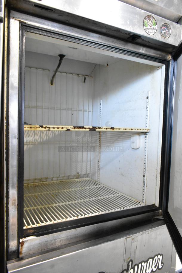 True T-23F-2 stainless steel commercial freezer with two half-size doors, interior shelving, used condition, on casters.