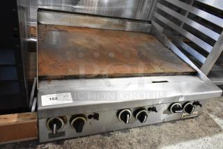 Garland stainless steel commercial gas griddle, flat top, used condition, visible wear on surface, control knobs shown.