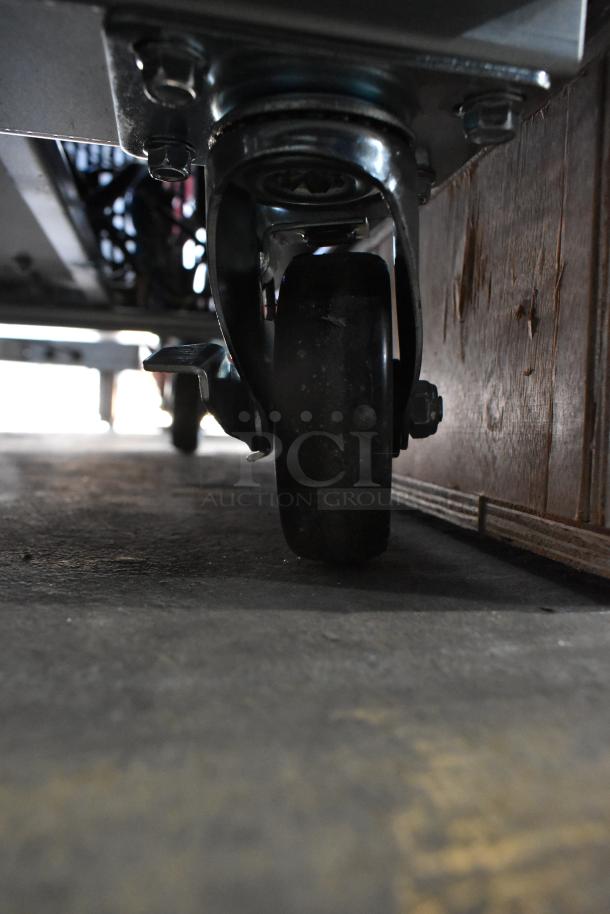 Close-up of a commercial caster wheel from the bottom of a 2025 Avantco 178GDC23HCB metal reach-in cooler.