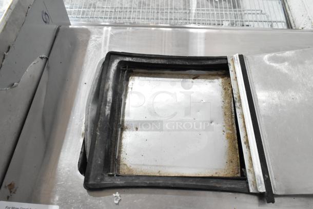Globe Metal Chest Freezer with visible wear, operates at 115 volts, 1 phase. Some rust and dirt around the edges.