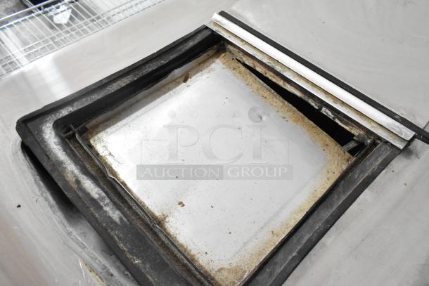 Globe Metal Chest Freezer, 115 volts, 1 phase, showing interior with signs of wear, metal structure visible.
