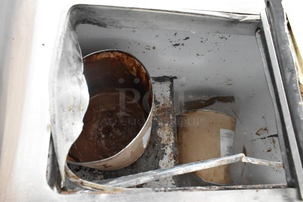 Globe Metal Chest Freezer interior, showing rust and wear. 115 volts, 1 phase. Contains old ice cream containers.