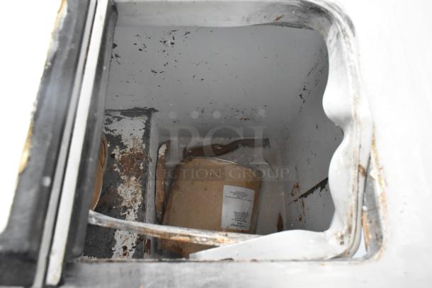 Globe Metal Chest Freezer interior view, showing a used condition with visible rust and debris. 115 volts, 1 phase.