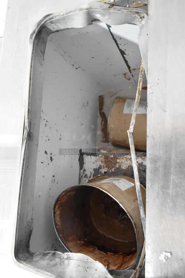 Globe Metal Chest Freezer, 115 Volts, 1 Phase. Visible signs of wear with interior cans present.