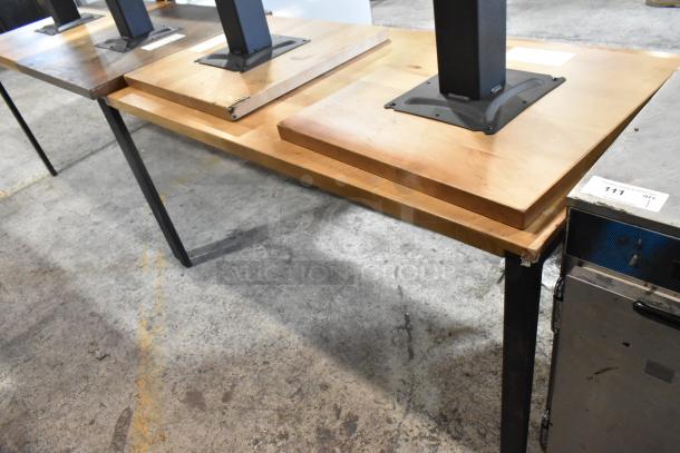 Six wooden tables with black metal legs and base, varying wood tones, used condition, auction lot number visible.