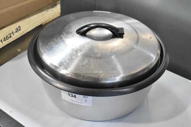 Brand new metal rice cooker insert with lid, scratch and dent condition, item tag 134 visible.