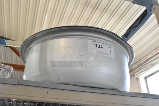 Brand new metal rice cooker insert with lid, showing minor scratches and dents. Auction label: "134, QTY 1, PCIAuctions.com".