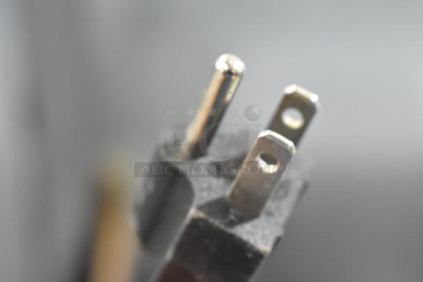 A close-up of a power plug, likely for the Avantco 194MCF430A ice machine, showing metal prongs and a black casing.