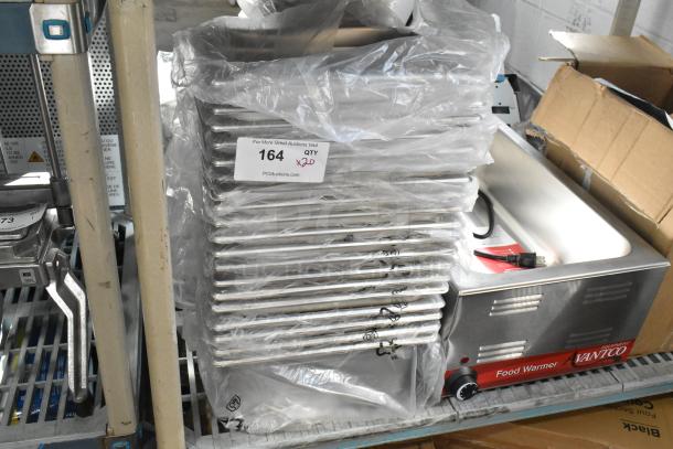 20 brand new stainless steel drop-in bins, labeled as scratch and dent, stacked in plastic packaging with quantity tag.