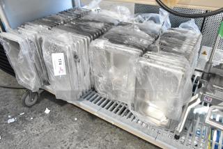 75 new stainless steel drop-in bins, some with minor scratches, in original packaging. Auction lot tag number 174 visible.