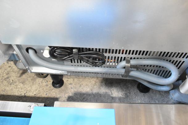 Alt text: Undercounter view of an Avantco 194UCH160A stainless steel ice machine, showing coiled cords and ventilation grill.