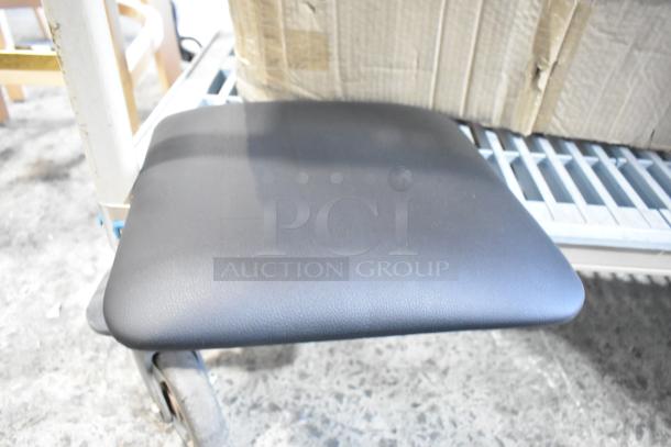 Box of brand new black seat cushions with minor blemishes, showing one cushion on a cart. Durable material, ideal for seating.