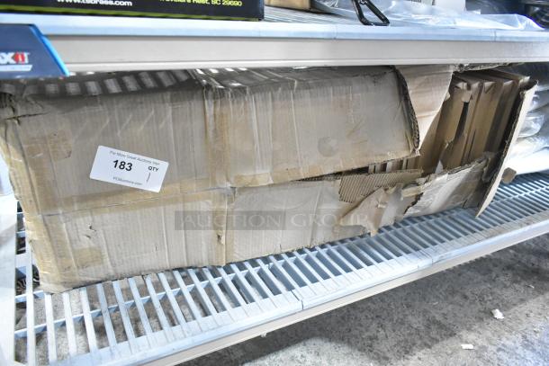 Box of black seat cushions, brand new with scratch and dent damage. Box number 183, visible at auction site.