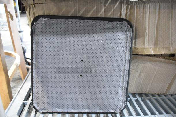 Box of black seat cushions with minor scratches. Cushions are square with a dotted pattern on the underside. Brand new condition.
