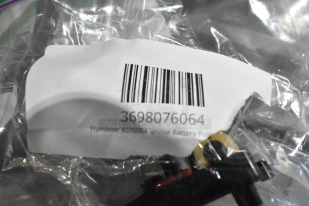 Frymaster 8076064 Ignitor Battery Push Button shown in packaging with barcode 3698076064, brand new condition.