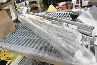 Three new pull-down screens for merchandisers, wrapped in plastic. Packaging labeled "189" and "Qty x3." Slightly damaged box visible.