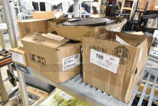 Boxes of scratch and dent items, including Avantco thermopile and Front of the House porcelain bowls, on a metal shelf.