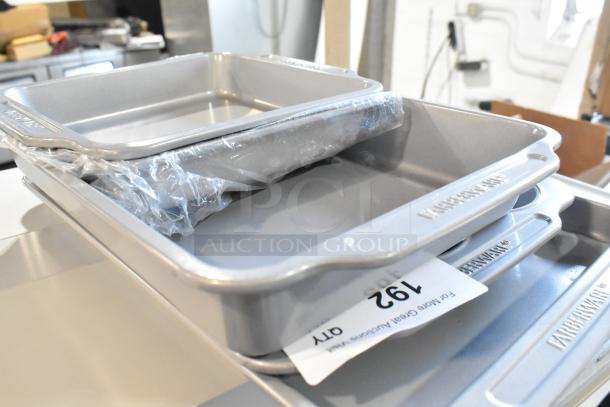 Set of 5 brand new Farberware baking pans, metallic finish, some scratch and dent, stacked with auction tag visible.