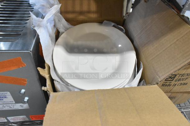 Four boxes of white ceramic dishes, new with minor scratches and dents. "Made in China" label visible.