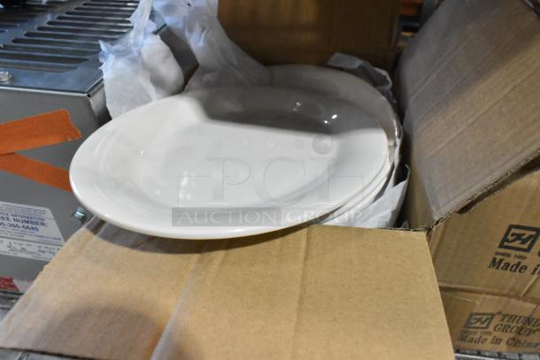 Four boxes of white ceramic dishes, brand new with minor scratches and dents. Packed in cardboard boxes.
