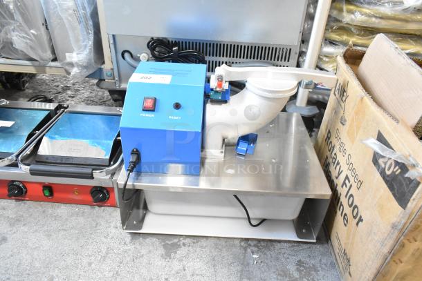 Brand new metal commercial countertop ice shaver, scratch and dent, 120 volts, 1 phase, blue power unit, on metal base.