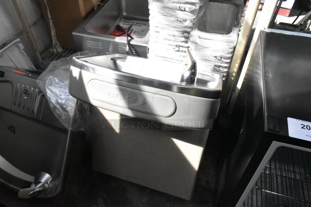 Brand new Elkay wall mount water fountain, scratch and dent condition, includes visible branding on the front.