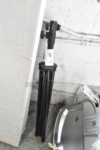 Metal tripod stand, new condition but labeled "scratch and dent," black finish, adjustable height, with 201 tag.